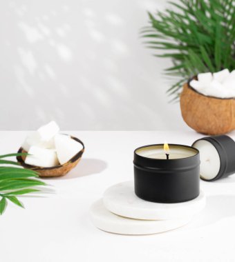 Siyah kavanozda hindistan cevizi mumu, ve yeşil yaprak, beyaz arka planda bitki. Doğal çevre dostu hindistan cevizi mumları. Moda konsepti. minimalist. İzometrik projeksiyon. Boşluğu kopyala
