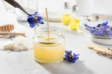 Ev yapımı doğal çevre dostu mumlar, fitil, parfüm, mermer bir masaya gerekli yağı koymak için gerekli aletleri ayarlayın. İşlem yapılıyor. Modayı takip et. El işi hobisi, küçük işletme, sanatsal ürünler konsepti.