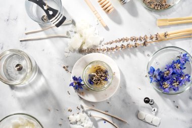 Ev yapımı doğal çevre dostu mumlar, fitil, parfüm, mermer bir masaya gerekli yağı koymak için gerekli aletleri ayarlayın. İşlem yapılıyor. Modayı takip et. El işi hobisi, küçük işletme, sanatsal ürünler konsepti.