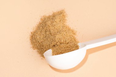 Mide sağlığı için biyolojik olarak aktif katkı maddelerinin karışımı. Beyaz kepçe bej arka planda diyet lifleri. Beslenme bitkisel takviyeler. Bağırsak ve mide sağlığı konsepti. Üst görünüm, yatay.