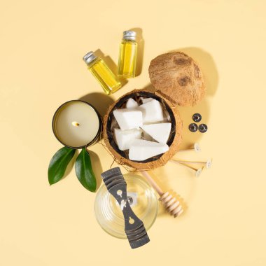 Ev yapımı doğal hindistan cevizi mumları, fitil, parfüm, aroma yağı. Mum yapımında kullanılan aletler. Bej arka planda soluk renkli mumlar. Kapatın. Acımasız vejetaryen ürünü.