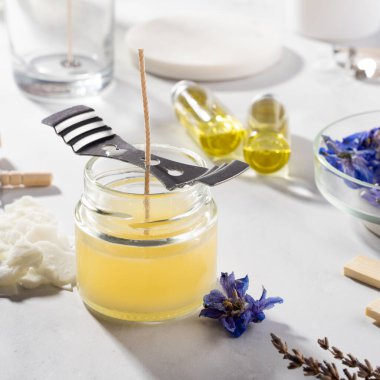 Ev yapımı doğal çevre dostu mumlar, fitil, parfüm, mermer bir masaya gerekli yağı koymak için gerekli aletleri ayarlayın. İşlem yapılıyor. Modayı takip et. El işi hobisi, küçük işletme, sanatsal ürünler konsepti.