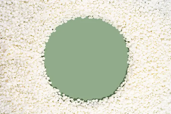 Organic soy wax on green background with copy space for design, text. Top view. frame border of vegan wax. Mockup blank copy space. Flat lay.