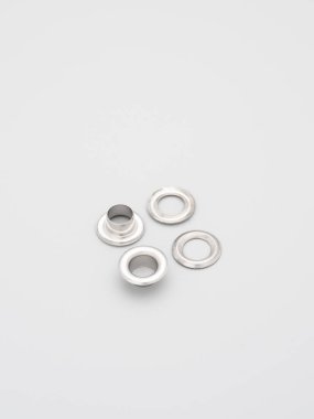 Gri arka planda duran çantalar, sırt çantaları ve dikiş malzemeleri için metal aksesuarlar ve malzemeler. Çantalar için krom kaplı metal çerçeveler. Dikiş, torba yapımı, kopyalama alanı.