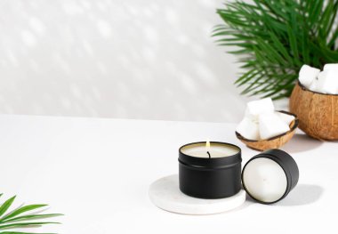 Beyaz arka planda siyah bir kavanozda hindistan cevizi mumu. Doğal çevre dostu hindistan cevizi mumları. Moda konsepti. minimalist. İzometrik projeksiyon. Boşluğu kopyala