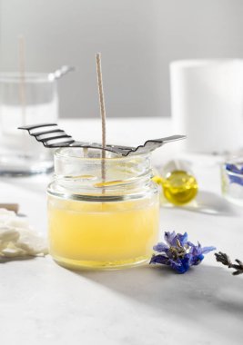 Ev yapımı doğal çevre dostu mumlar, fitil, parfüm, mermer bir masaya gerekli yağı koymak için gerekli aletleri ayarlayın. İşlem yapılıyor. Modayı takip et. El işi hobisi, küçük işletme, sanatsal ürünler konsepti.