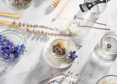 Ev yapımı doğal çevre dostu mumlar, fitil, parfüm, mermer bir masaya gerekli yağı koymak için gerekli aletleri ayarlayın. İşlem yapılıyor. Modayı takip et. El işi hobisi, küçük işletme, sanatsal ürünler konsepti.