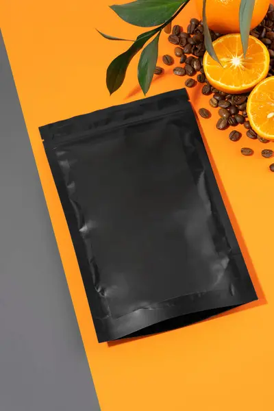 A package of anti-cellulite dry scrub lying on an orange background. Body scrub with essential oils of lime, coffee and mandarin. Cosmetic product for peeling and spa care, body beauty. Copy space.