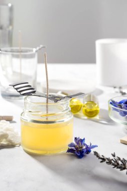 Ev yapımı doğal çevre dostu mumlar, fitil, parfüm, mermer bir masaya gerekli yağı koymak için gerekli aletleri ayarlayın. İşlem yapılıyor. Modayı takip et. El işi hobisi, küçük işletme, sanatsal ürünler konsepti.