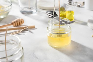 Ev yapımı doğal çevre dostu mumlar, fitil, parfüm, mermer bir masaya gerekli yağı koymak için gerekli aletleri ayarlayın. İşlem yapılıyor. Modayı takip et. El işi hobisi, küçük işletme, sanatsal ürünler konsepti.