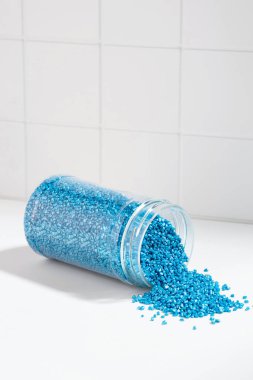 Banyo duvarının arka planında mavi parlak kristal tuz paketi var. Kavanozda mavi deniz tuzu var. Rahatlama, aromaterapi ve kişisel bakım fikri. Deniz suyunun saç üzerindeki etkisi.