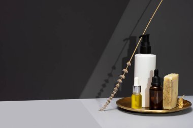 Doğal kozmetiklerle yaratıcılık dolu bir hayat. Gerekli yağlar, el yapımı sabun ve koyu gri arka planda kurutulmuş lavanta. Kişisel bakım ve organik ürünler kavramı. Minimalizm, boşluğu kopyala.