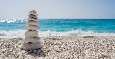 Akdeniz 'de güzel beyaz bir çakıl taşı plajında istiflenmiş taşlar.