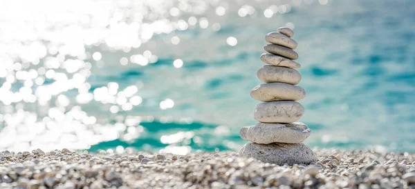 Stacked stones on a beautiful white pebble beach in the Mediterranean