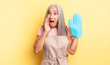 Orta yaşlı, güzel bir kadın şok olmuş ve korkmuş hissediyor. fırın eldiveni kavramı