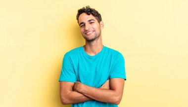 İspanyol yakışıklı adam kolları bağlı mutlu bir şekilde gülüyor.