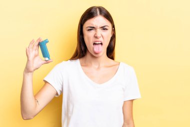 Genç İspanyol kadın iğreniyor, sinirleniyor ve dili dışarı çıkıyor. astım konsepti