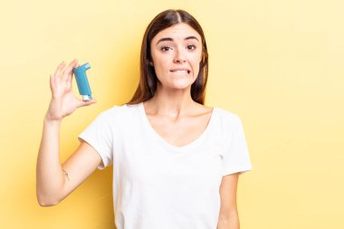 Genç İspanyol kadın şaşkın ve şaşkın görünüyor. astım konsepti