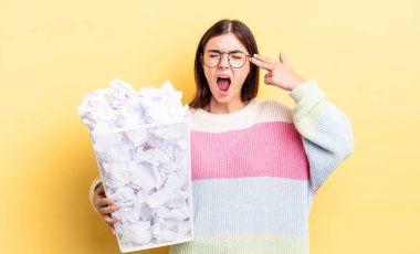 Genç İspanyol kadın mutsuz ve stresli görünüyor, intihar jesti silah işareti yapıyor. başarısızlık çöp konsepti