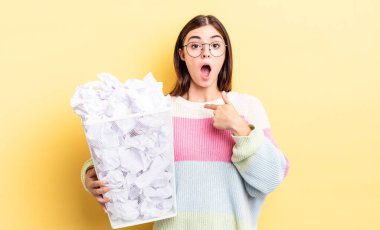 Genç İspanyol kadın şok olmuş ve ağzı açık, kendini işaret ederek şaşırmış görünüyor. başarısızlık çöp konsepti