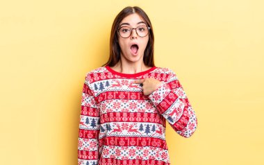 Genç İspanyol kadın şok olmuş ve ağzı açık, kendini işaret ederek şaşırmış görünüyor. Chistmas ve yeni yıl konsepti