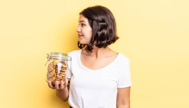 Profil görünümlü genç İspanyol kadın hayal mi kuruyor yoksa hayal mi kuruyor? kurabiye şişesi konsepti