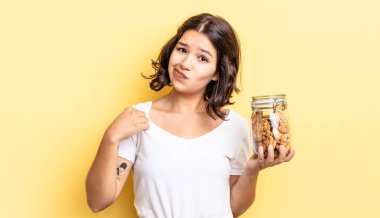 Genç İspanyol kadın kibirli, başarılı, pozitif ve gururlu görünüyor. kurabiye şişesi konsepti