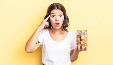 Genç İspanyol kadın şaşırmış görünüyor, yeni bir düşünce, fikir ya da konsept keşfediyor. kurabiye şişesi konsepti