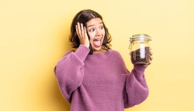 Genç İspanyol kadın mutlu, heyecanlı ve şaşırmış hissediyor. kahve çekirdeği konsepti