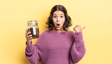 İnançsızlığa şaşırmış genç İspanyol kadın. kahve çekirdeği konsepti