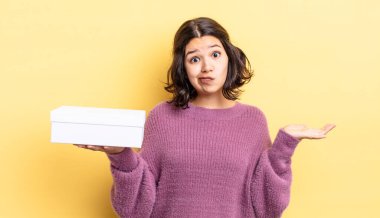 Genç İspanyol kadın şaşkın, şaşkın ve şüpheci hissediyor. boş kutu kavramı