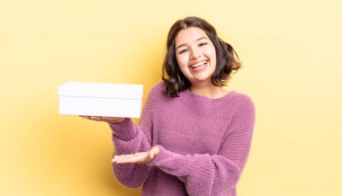 Genç İspanyol kadın neşeyle gülümsüyor, mutlu hissediyor ve bir konsept gösteriyor. boş kutu kavramı