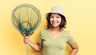 Genç İspanyol kadın mutlu bir şekilde gülümsüyor, eli kalçasında ve kendinden emin. balıkçı ağı kavramı