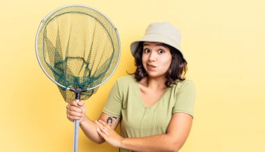 Genç İspanyol kadın omuz silkiyor, kafası karışık ve kararsız. balıkçı ağı kavramı