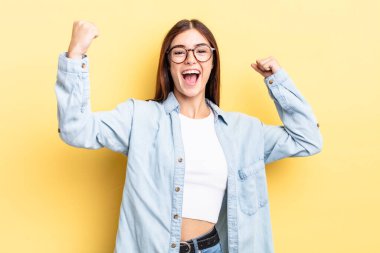 İspanyol güzel kadın muzaffer bir şekilde bağırıyor. Heyecanlı, mutlu ve şaşırmış görünüyor. Kutlama yapıyor.