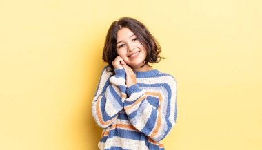 Genç, güzel bir kız aşık ve sevimli görünüyor. Sevimli ve mutlu. Romantik bir şekilde gülümsüyor.