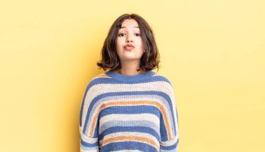 Genç ve güzel bir kız dudaklarını birbirine bastırıyor. Sevimli, eğlenceli, mutlu, sevimli bir yüz ifadesiyle. Öpücük gönderiyor.