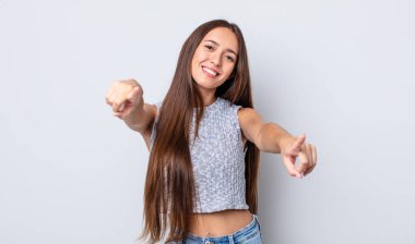 İspanyol güzel kadın mutlu ve kendinden emin, kamerayı iki eliyle gösteriyor ve gülüyor, seni seçiyor.