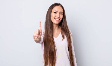 İspanyol güzel kadın gururla gülümsüyor ve bir numaralı pozu başarıyla veriyor, kendini lider gibi hissediyor.