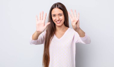 İspanyol güzel kadın gülümsüyor ve arkadaş canlısı görünüyor. 9 ya da 9 numarayı gösteriyor. Elleri önde ve geri sayıyor.