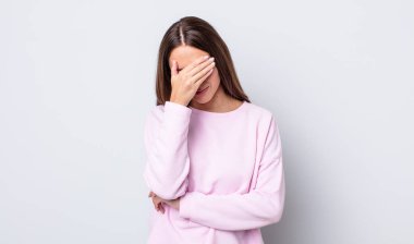 İspanyol güzel kadın stresli, utanmış ya da üzgün görünüyor, baş ağrısı var, yüzünü eliyle kapatıyor.