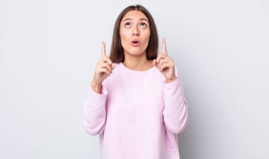 Hispanik güzel kadın şaşkınlık içinde ve ağzı açık. Şok olmuş ve şaşırmış bir bakışla yukarı bakıyor.