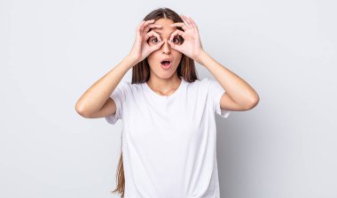 İspanyol güzel kadın şaşkın, şaşkın ve şaşırmış hissediyor, elinde şaşkın, inançsız bir bakışla gözlük tutuyor.