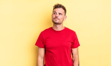 Endişeli, kafası karışık, cahil bir ifadeyle genç, yakışıklı İspanyol adam, kopya alanı arıyor, şüpheci