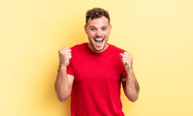 Genç, yakışıklı İspanyol adam şok olmuş, heyecanlı ve mutlu hissediyor, gülüyor ve başarıyı kutluyor,!