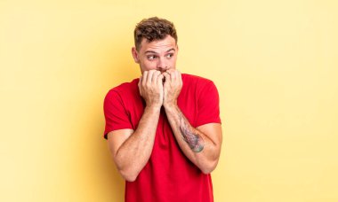 Genç, yakışıklı, endişeli, stresli ve korkmuş görünen, tırnaklarını yiyen ve yanal fotokopi alanı arayan bir İspanyol.