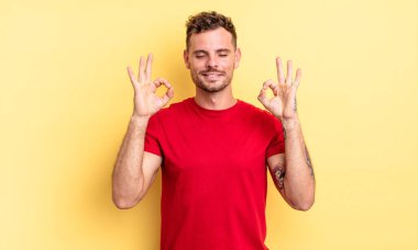 Genç ve yakışıklı İspanyol adam konsantre ve meditasyon yapıyor, kendini tatmin olmuş ve rahatlamış hissediyor, düşünüyor ya da bir seçim yapıyor.