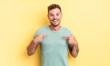 Genç, yakışıklı İspanyol adam mutlu, şaşkın ve gururlu hissediyor. Heyecanlı ve şaşkın bir bakışla kendini işaret ediyor.