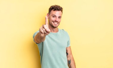 Genç, yakışıklı İspanyol adam gururla gülümsüyor ve bir numaralı pozunu başarıyla veriyor, kendini lider gibi hissediyor.