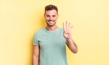 Genç, yakışıklı İspanyol adam gülümsüyor ve arkadaş canlısı görünüyor. Elleri önde, geriye doğru sayıyor.